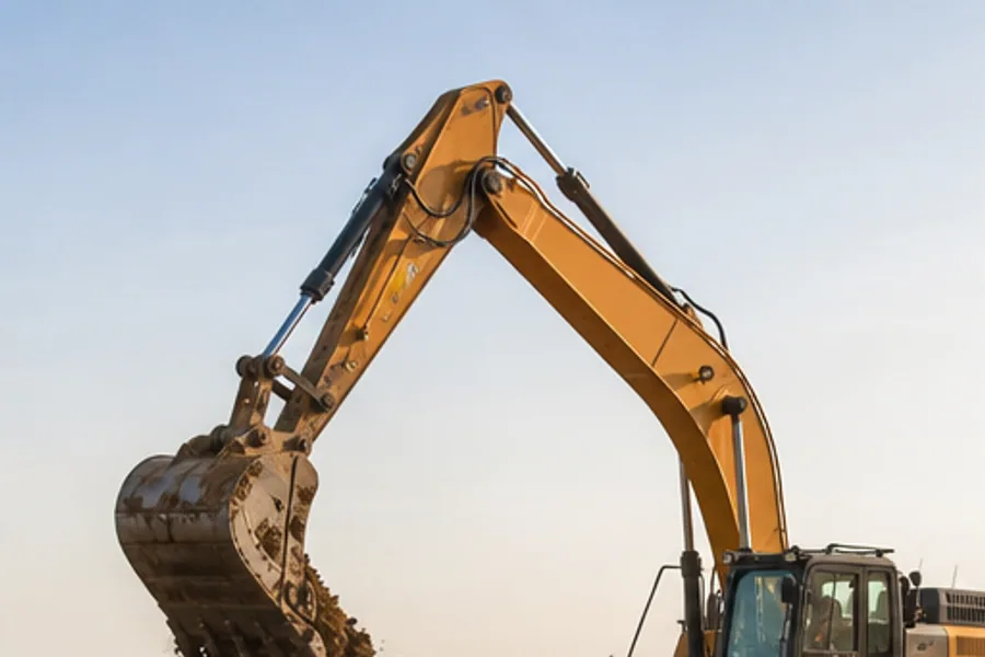 An excavator loading trucks